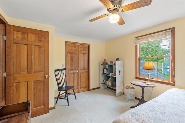 bedroom featuring light carpet, a closet, baseboards, and ceiling fan