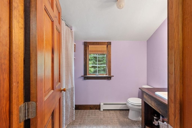 bathroom with baseboard heating, toilet, vanity, and baseboards