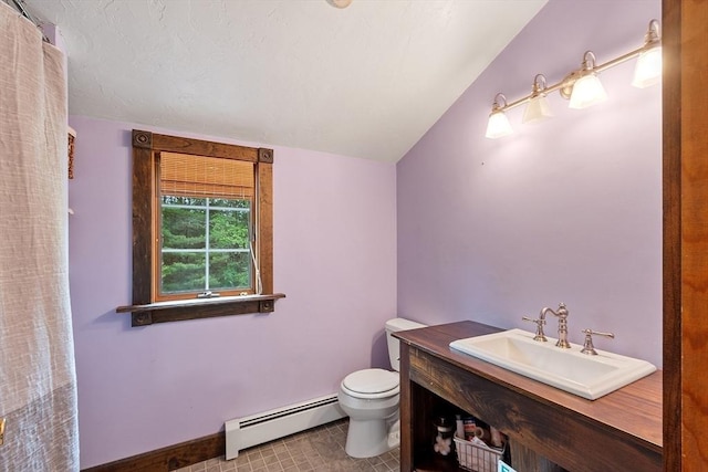 bathroom with a baseboard heating unit, toilet, lofted ceiling, vanity, and baseboards
