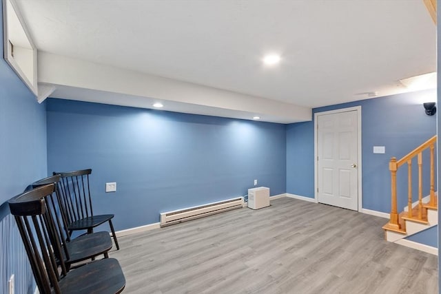 unfurnished room with a baseboard radiator, light wood-style flooring, baseboards, stairs, and recessed lighting