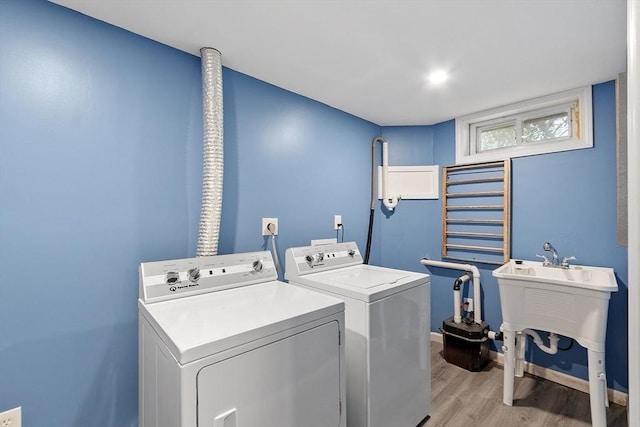 washroom featuring separate washer and dryer, light wood-style floors, and baseboards