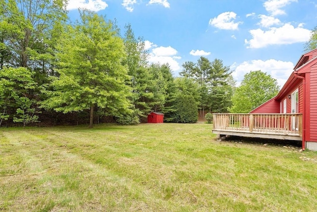 view of green lawn featuring a wooden deck