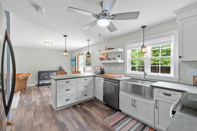 kitchen with stainless steel dishwasher, a sink, a peninsula, fridge, and dark wood-style flooring