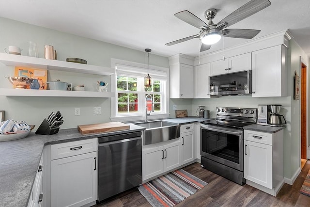 kitchen featuring stainless steel appliances, a sink, dark wood-type flooring, and white cabinetry