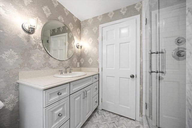 full bathroom with wallpapered walls, a stall shower, and vanity