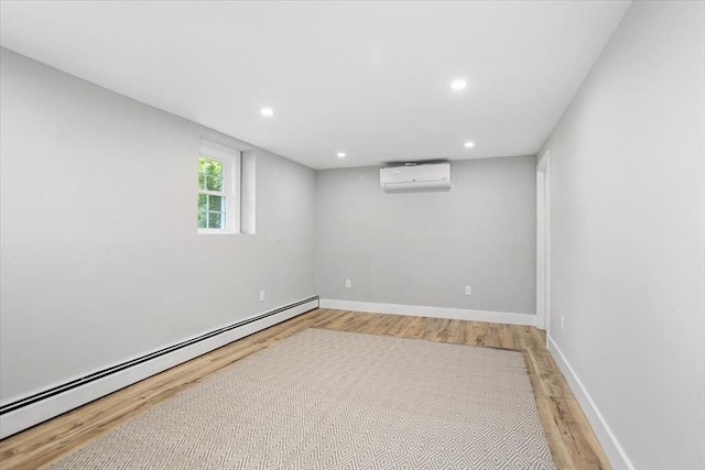 empty room with a baseboard heating unit, a wall mounted air conditioner, light wood finished floors, recessed lighting, and baseboards