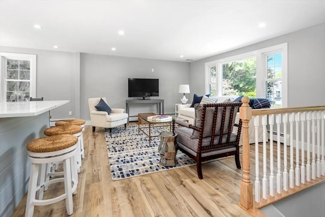living room with light wood finished floors, recessed lighting, and a baseboard radiator