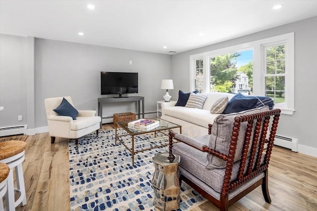 living room with wood finished floors, a baseboard heating unit, baseboards, and recessed lighting