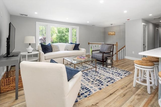 living area featuring light wood-style flooring, recessed lighting, baseboards, and a chandelier