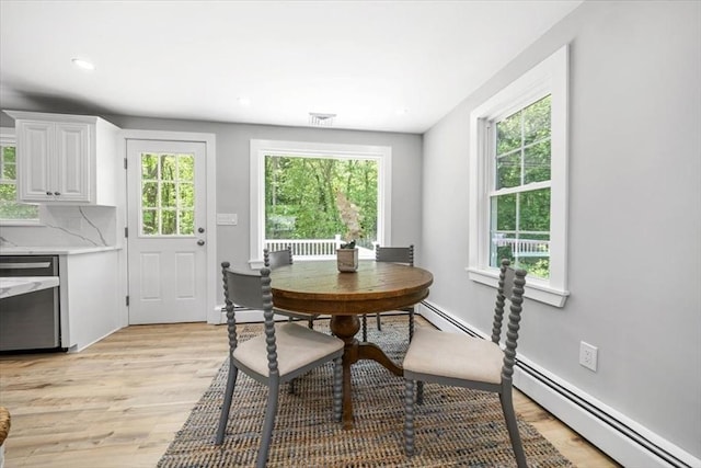 dining room featuring plenty of natural light, light wood-style flooring, recessed lighting, and a baseboard radiator