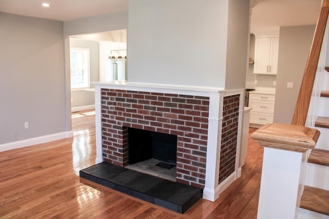 6 Lovis Ave, Wakefield, MA 01880 - details featuring high end fridge, wood finished floors, baseboards, a brick fireplace, and recessed lighting