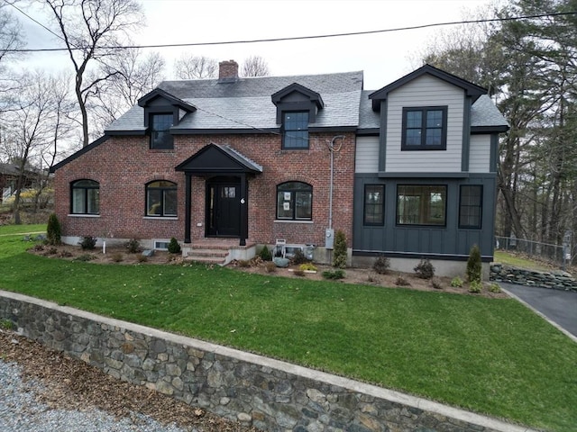 6 Lovis Ave, Wakefield, MA 01880 - view of front of house featuring a chimney, brick siding, a front yard, and roof with shingles