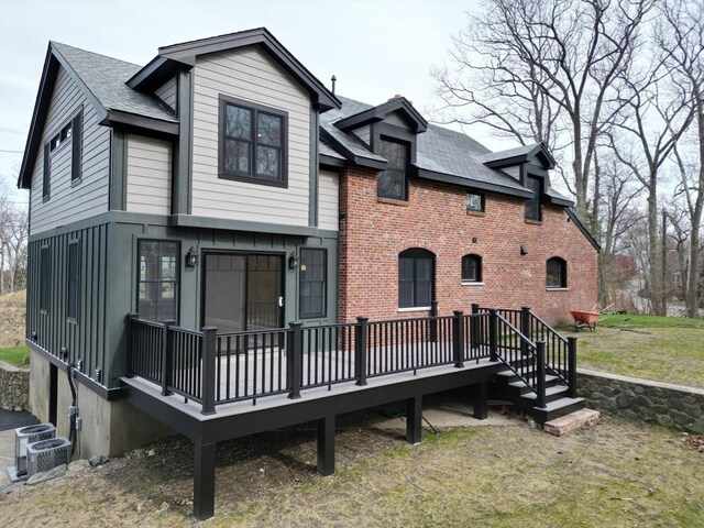 6 Lovis Ave, Wakefield, MA 01880 - back of property with roof with shingles, cooling unit, brick siding, and a wooden deck