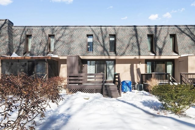 townhome / multi-family property with a deck, a shingled roof, and mansard roof