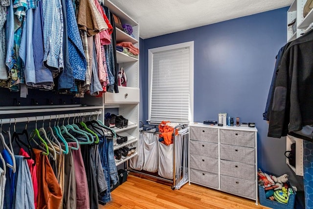 walk in closet with wood finished floors