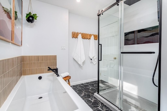 full bath featuring baseboards, a stall shower, and a bath