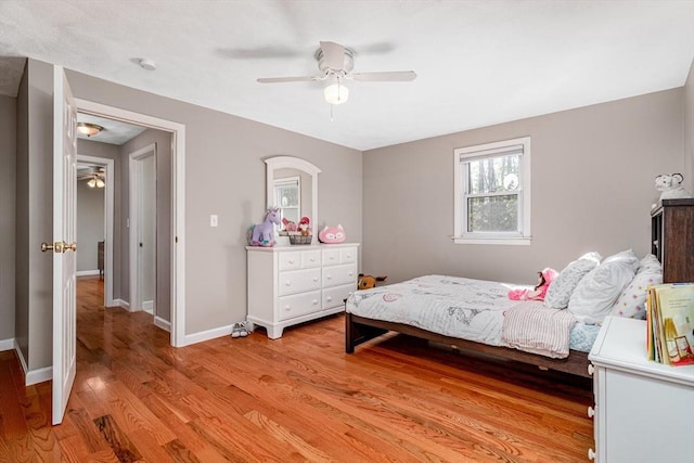 bedroom featuring light wood-type flooring, a ceiling fan, and baseboards