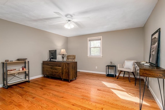 office space featuring light wood-style floors, baseboards, and ceiling fan