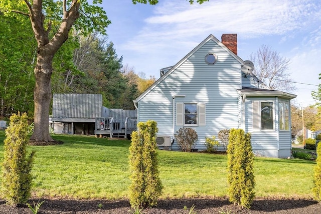 view of home's exterior with a yard, a chimney, and a wooden deck