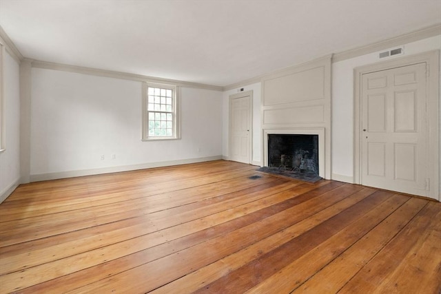 unfurnished living room featuring crown molding and light hardwood / wood-style floors