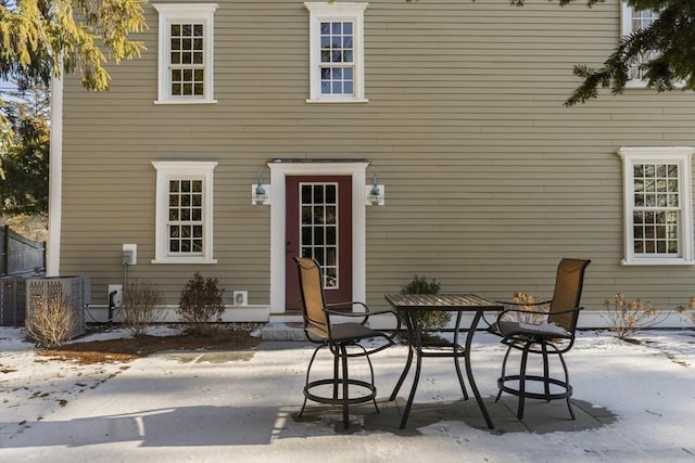 snow covered property featuring central AC and a patio