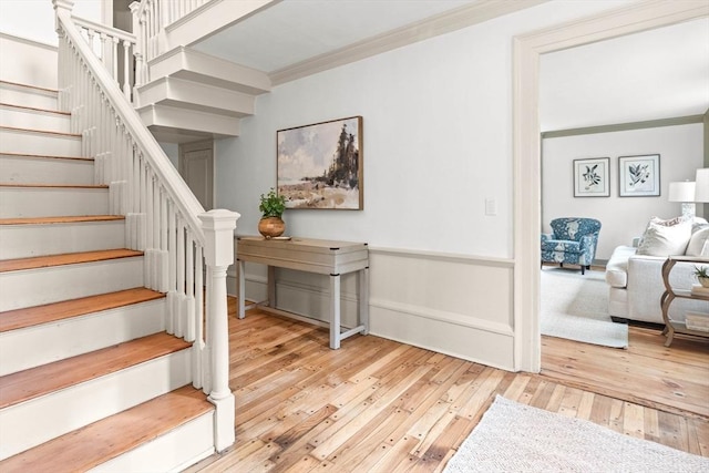 staircase featuring ornamental molding and hardwood / wood-style floors