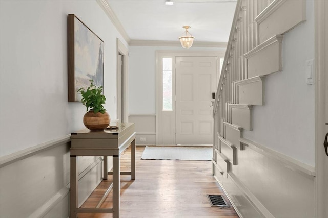 foyer featuring crown molding and light hardwood / wood-style flooring