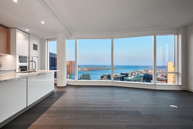 240 Devonshire St Unit 3708, Boston, MA 02110 - kitchen with modern cabinets, white cabinetry, a water view, double oven, and light stone countertops
