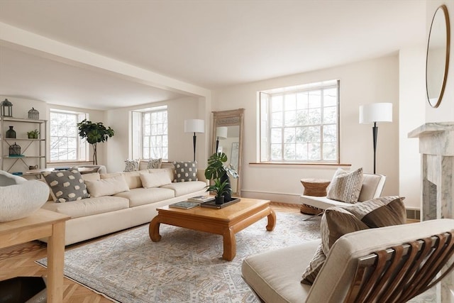 living room featuring a high end fireplace and light parquet floors