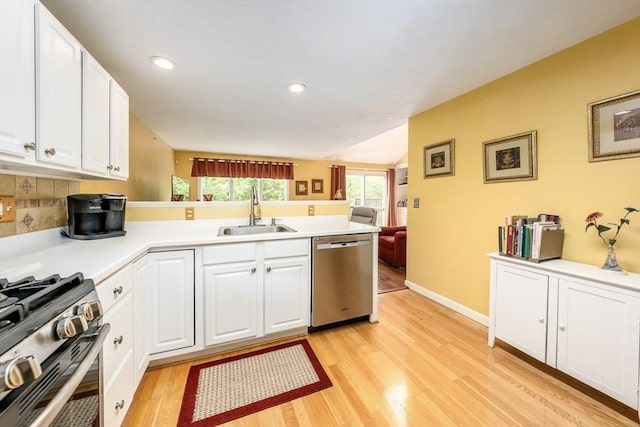 151 Leisure Green Dr N Unit 750, Mashpee, MA 02649 - kitchen featuring appliances with stainless steel finishes, a peninsula, light wood-style floors, white cabinetry, and light countertops