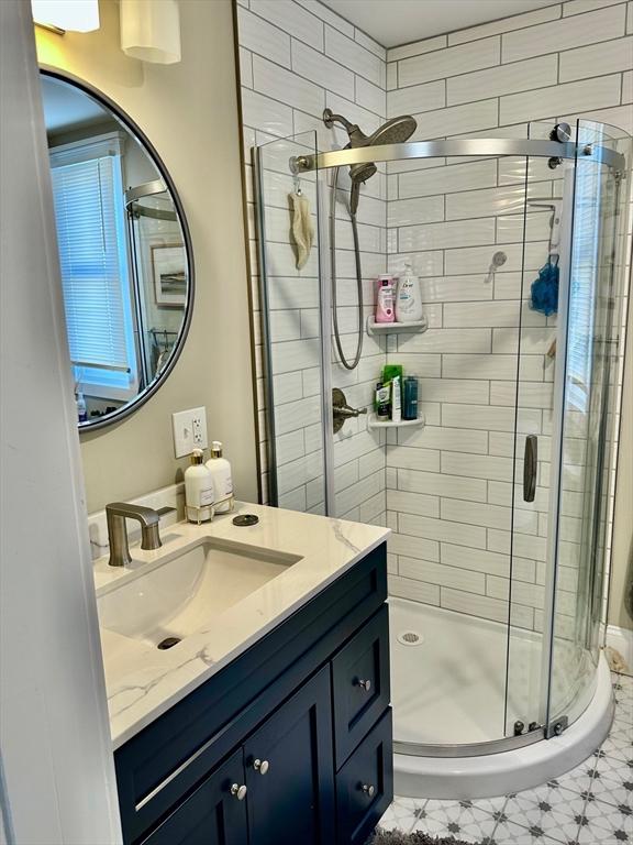 bathroom with a stall shower and vanity