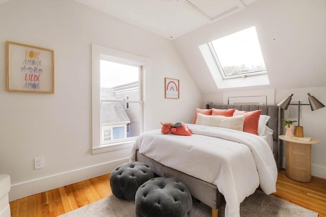 bedroom with vaulted ceiling, wood finished floors, and baseboards