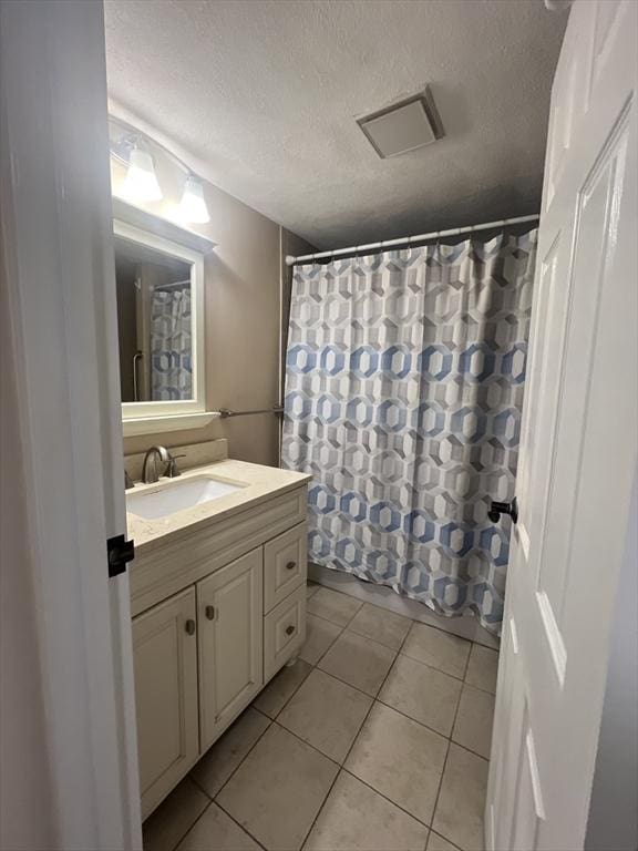 9 Broadway Unit 210, Saugus, MA 01906 - full bathroom with vanity, tile patterned floors, a textured ceiling, and a shower with shower curtain