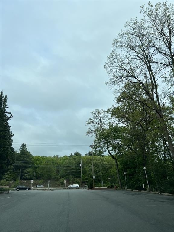 9 Broadway Unit 210, Saugus, MA 01906 - view of asphalt road featuring a forest view and curbs