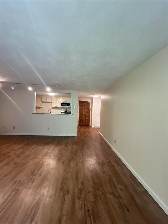 9 Broadway Unit 210, Saugus, MA 01906 - unfurnished living room featuring baseboards and dark wood finished floors