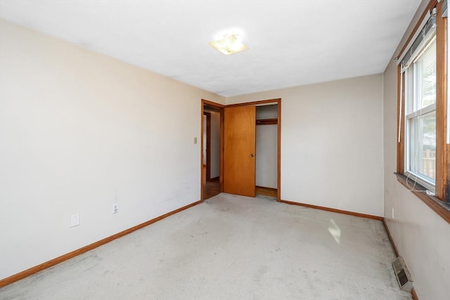 unfurnished bedroom with light carpet and a closet