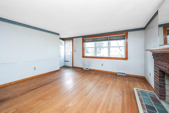 unfurnished living room with a fireplace and light hardwood / wood-style floors