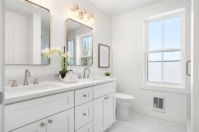 bathroom with a healthy amount of sunlight, visible vents, and a sink