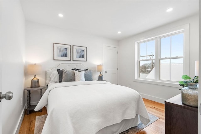 bedroom with light wood finished floors, baseboards, and recessed lighting