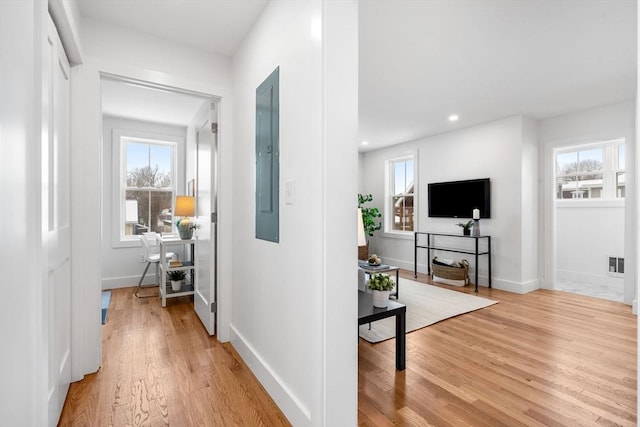 hall with recessed lighting, visible vents, baseboards, electric panel, and light wood finished floors