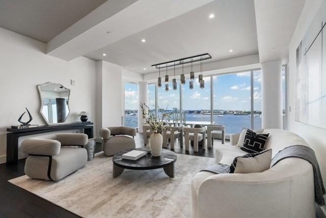 living room with wood-type flooring, a water view, and a wealth of natural light