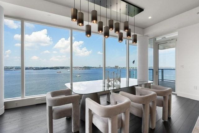 sunroom featuring a water view