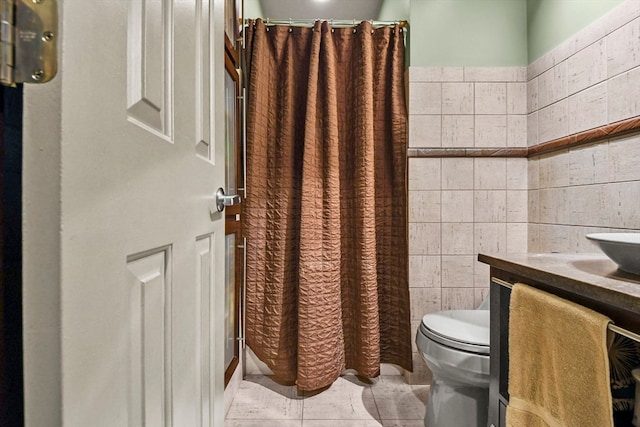 bathroom featuring vanity, tile patterned floors, tile walls, toilet, and a shower with shower curtain