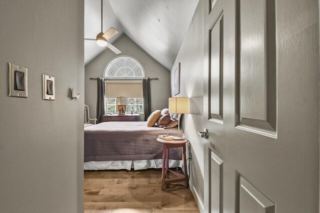 bedroom with ceiling fan, lofted ceiling, and light hardwood / wood-style floors