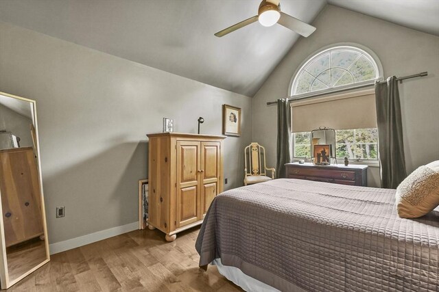 bedroom featuring light hardwood / wood-style floors, ceiling fan, and vaulted ceiling