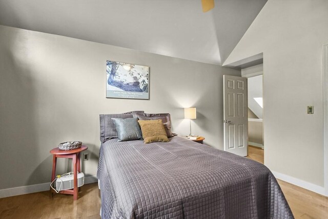 bedroom featuring wood-type flooring and vaulted ceiling