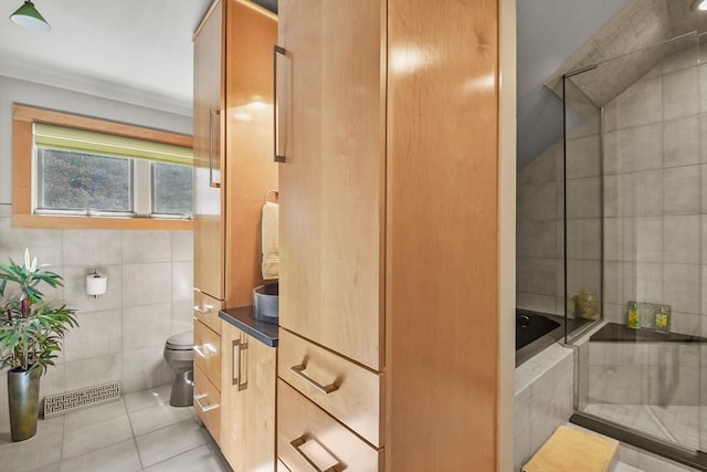 full bathroom featuring tile walls, tile patterned flooring, shower / bath combination with glass door, vanity, and toilet