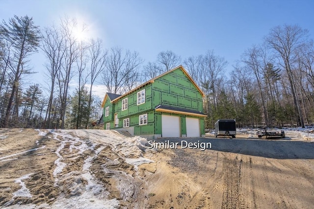 view of front of home with a garage and dirt driveway