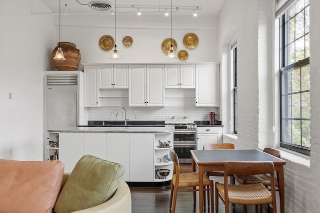 150 Moody St Unit 34, Waltham, MA 02453 - kitchen with open shelves, double oven range, backsplash, and white cabinetry
