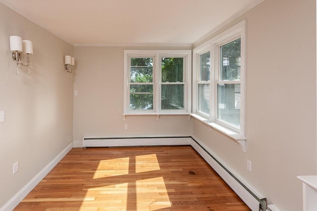 unfurnished room with baseboards, light wood finished floors, ornamental molding, a baseboard heating unit, and baseboard heating